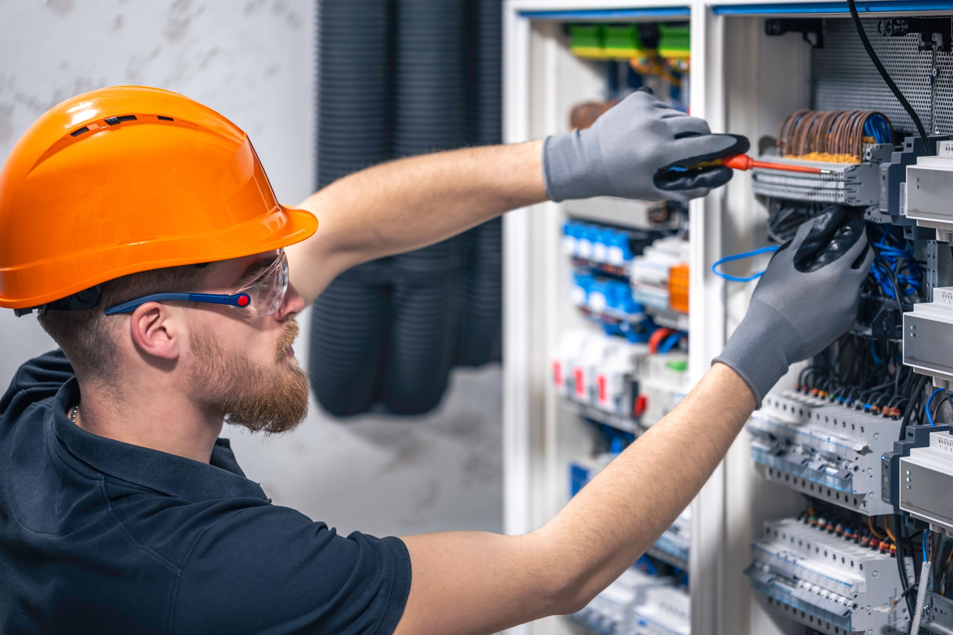 Male electrician working in a switchboard with fuses.